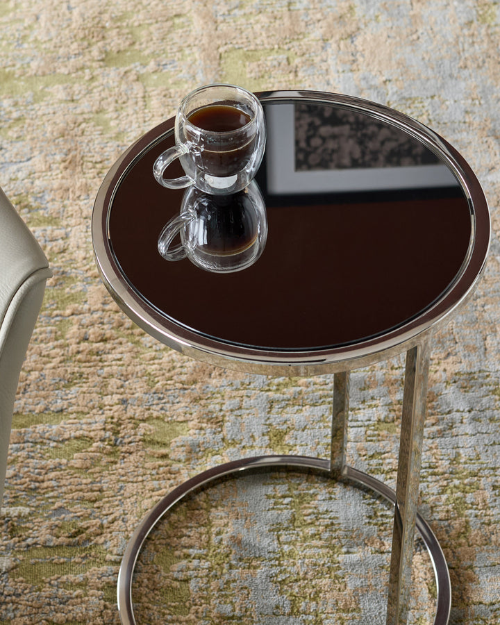 Sepia textured rug with mixed metallics, shown beneath a round side table with glass cup.