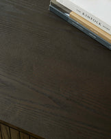 A dark wood furniture surface with the books 'The Kinfolk Home' and 'Gallery Direct Lighting' on display.