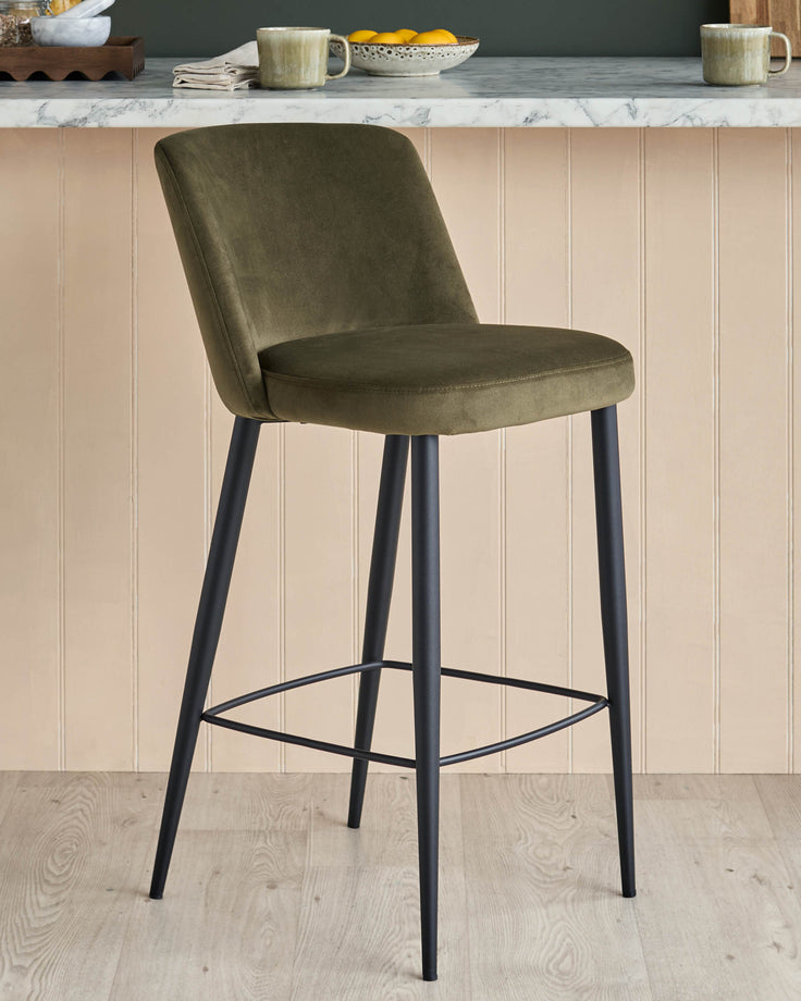 Stylish green velvet bar stool with sleek black metal legs, perfect for adding a touch of modern elegance to your kitchen.
