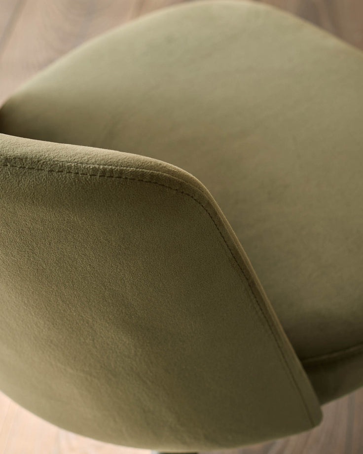 Close-up of a stylish, olive green upholstered chair with clean lines, showcasing its texture and design detail.