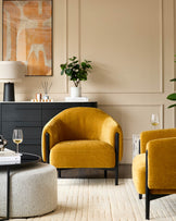 Stylish living room with mustard yellow armchairs, sleek black cabinet and textured rug. Perfect for a modern home.
