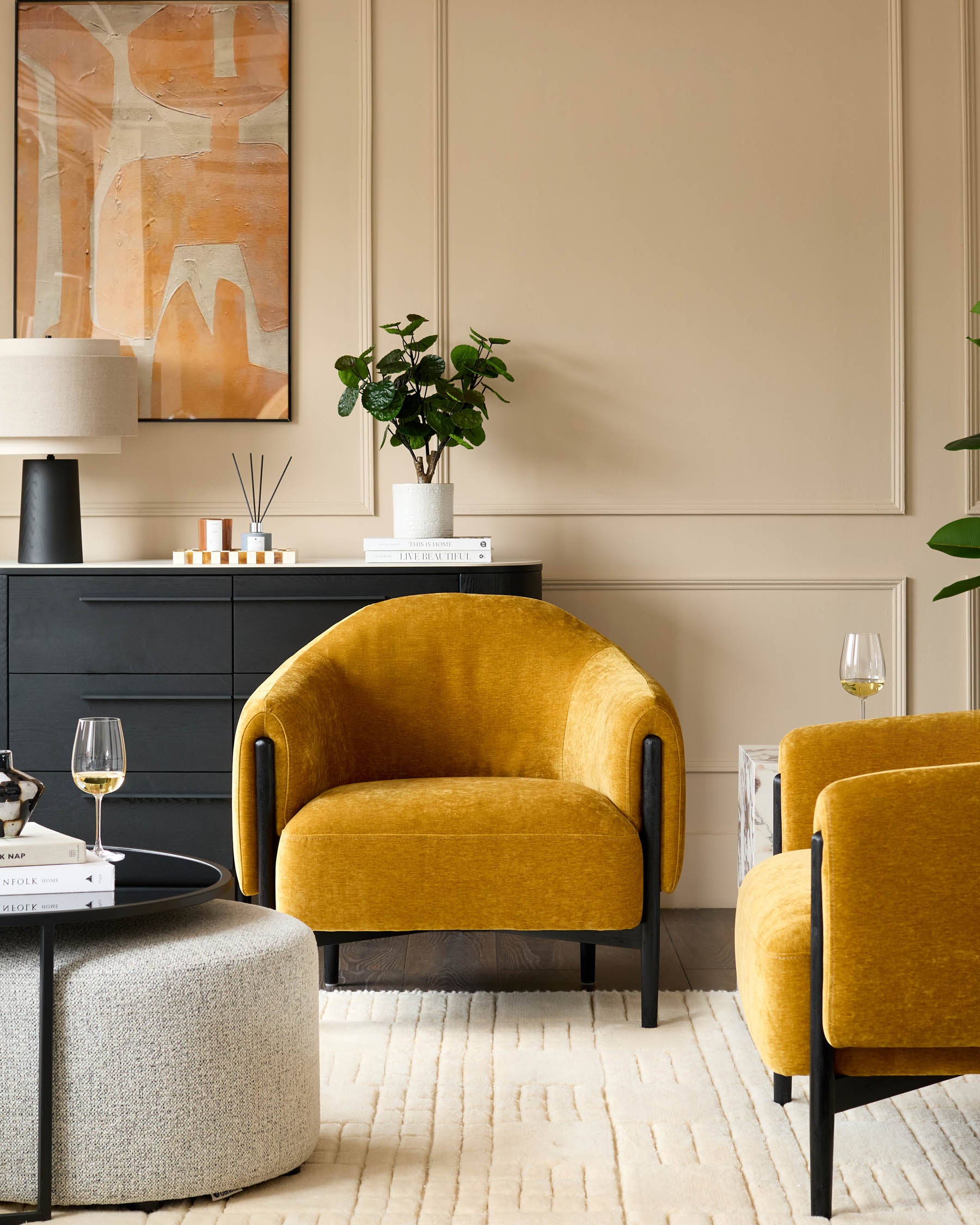 Stylish living room with mustard yellow armchairs, sleek black cabinet and textured rug. Perfect for a modern home.