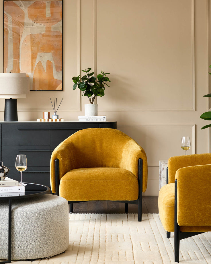 Stylish living room with mustard yellow armchairs, sleek black cabinet and textured rug. Perfect for a modern home.