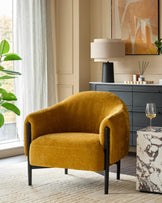 A mustard yellow armchair with black wooden legs, a grey cabinet, and a faux marble side table, creating a stylish living space.