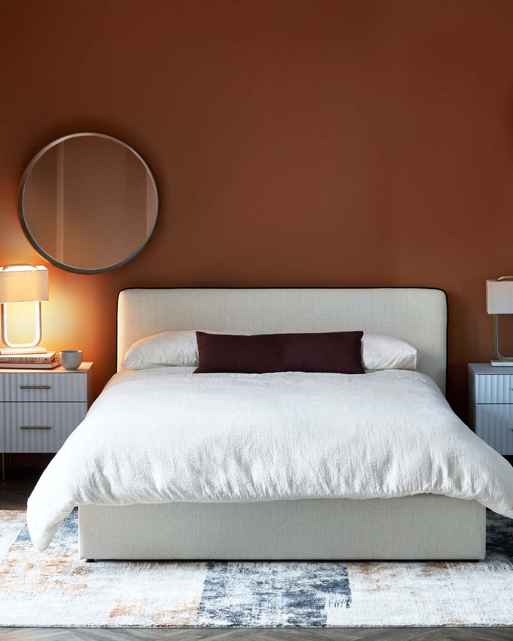Bedroom featuring a double bed, bedside tables, lamps, a rug and a round mirror, showcasing a modern and cosy design.