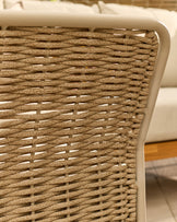 Close-up of woven natural rattan weave on cream-framed garden sofa back panel detail.