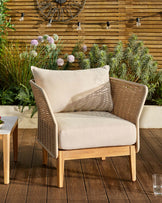 Tuscany garden armchair in natural acacia wood with woven rattan sides and cream cushions, positioned on a wooden deck.