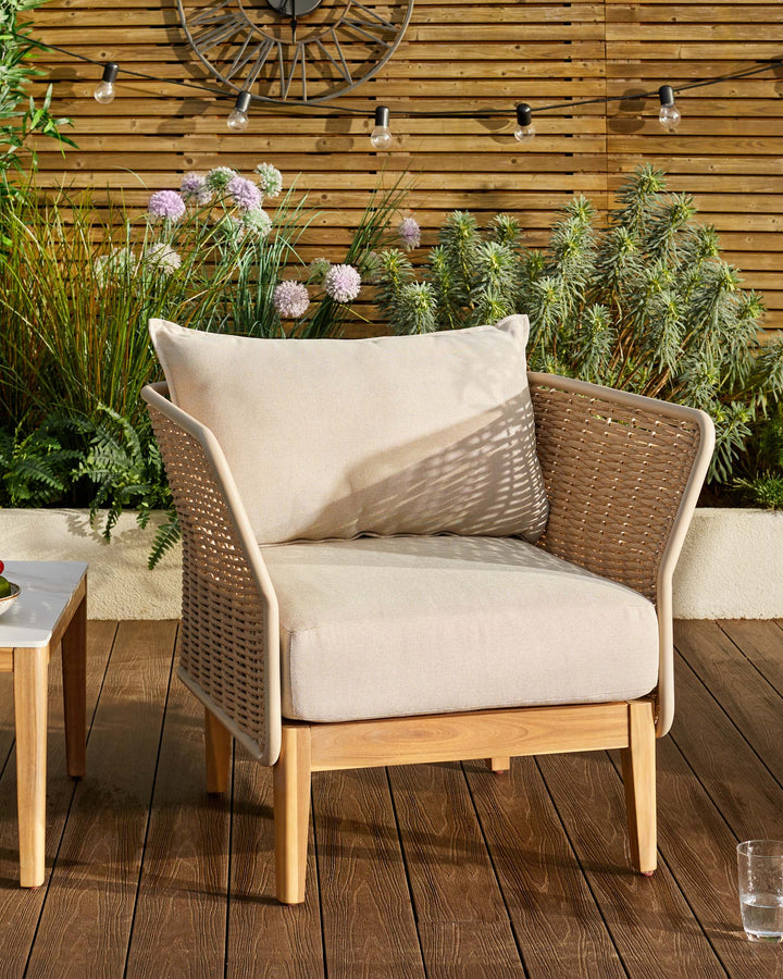 Tuscany garden armchair in natural acacia wood with woven rattan sides and cream cushions, positioned on a wooden deck.