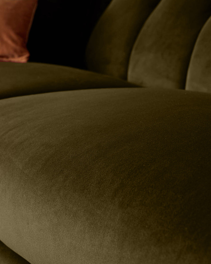 Valentina 2-seater sofa in olive green recycled velvet, close-up of curved armrest and seat cushion showing soft texture.