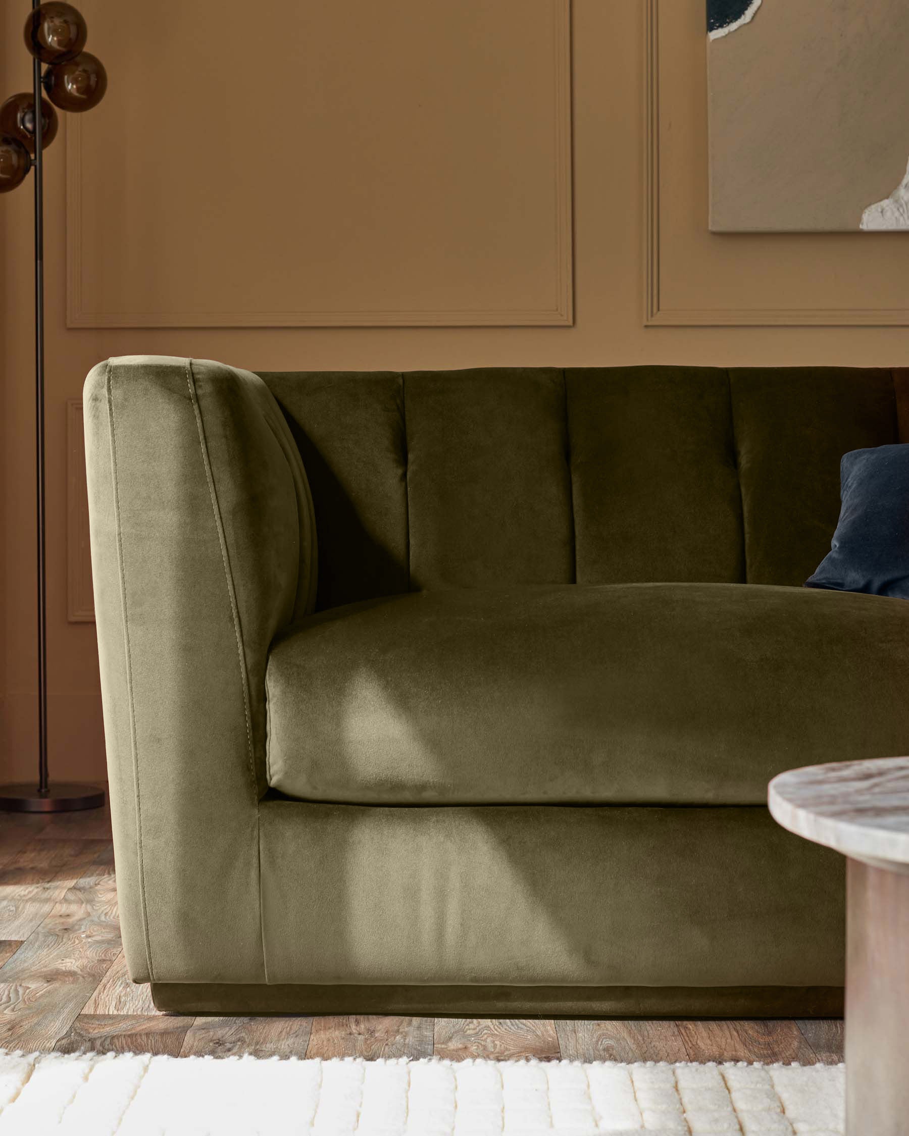 Valentina 3-seater sofa in olive green recycled velvet, shown from side angle in contemporary living room setting.