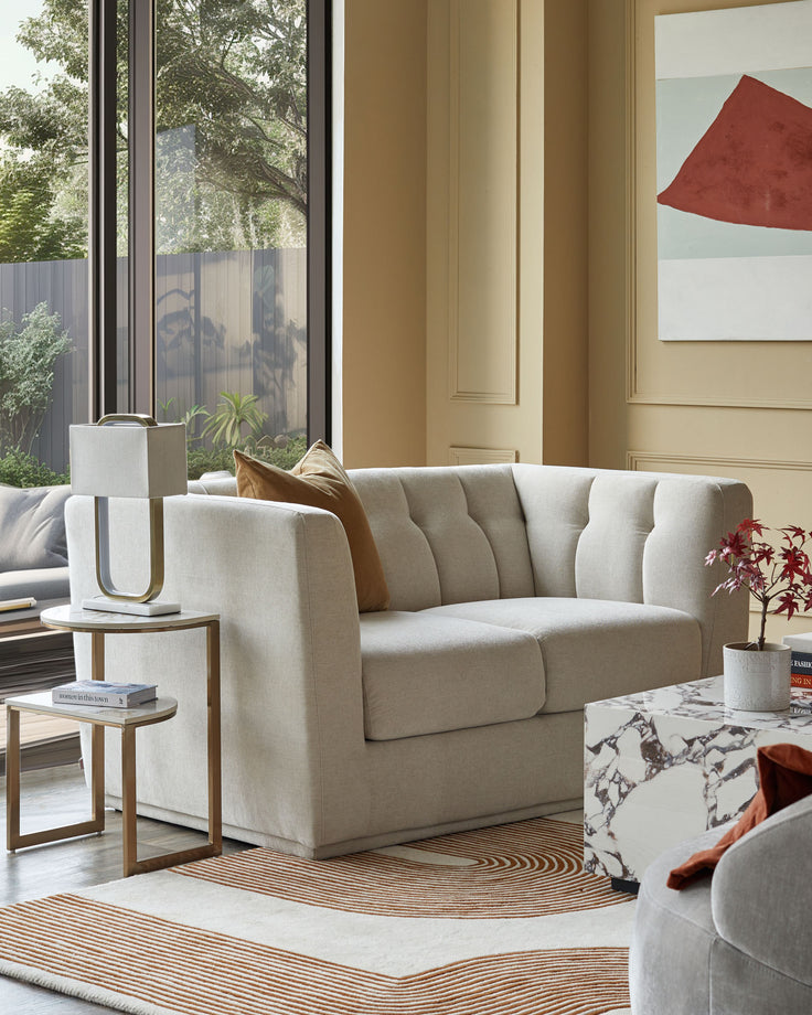 A stylish living room featuring a neutral sofa, marble coffee table, and eye-catching geometric rug. Modern, elegant design.