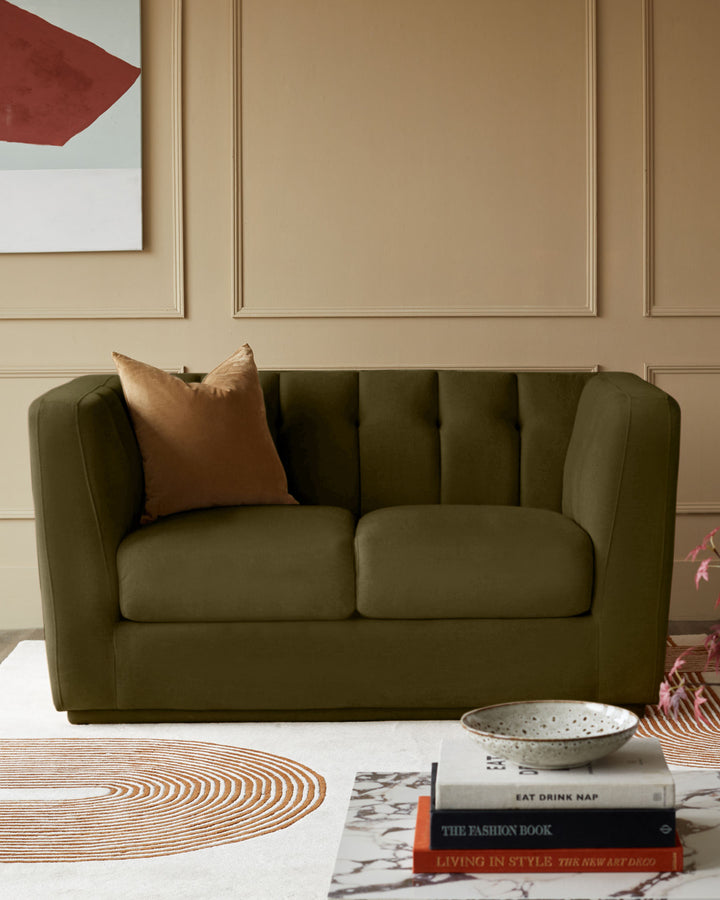 Valentina 2-seater sofa in olive green recycled velvet, featuring channel-quilted backrest and rounded arms, styled in a modern living room.