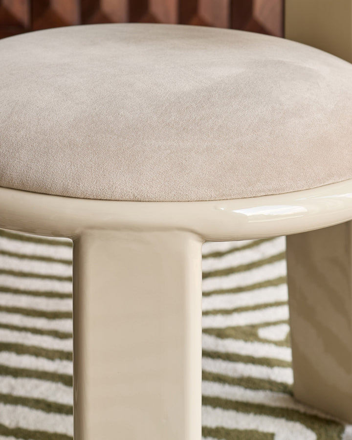 Valerie dining chair in champagne velvet, close-up of rounded seat with cream base and striped upholstered back.