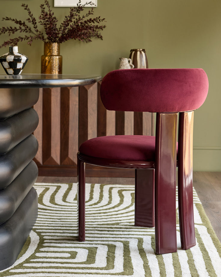 Valerie dining chair in plum velvet with burgundy finish wood frame, shown in styled room setting.
