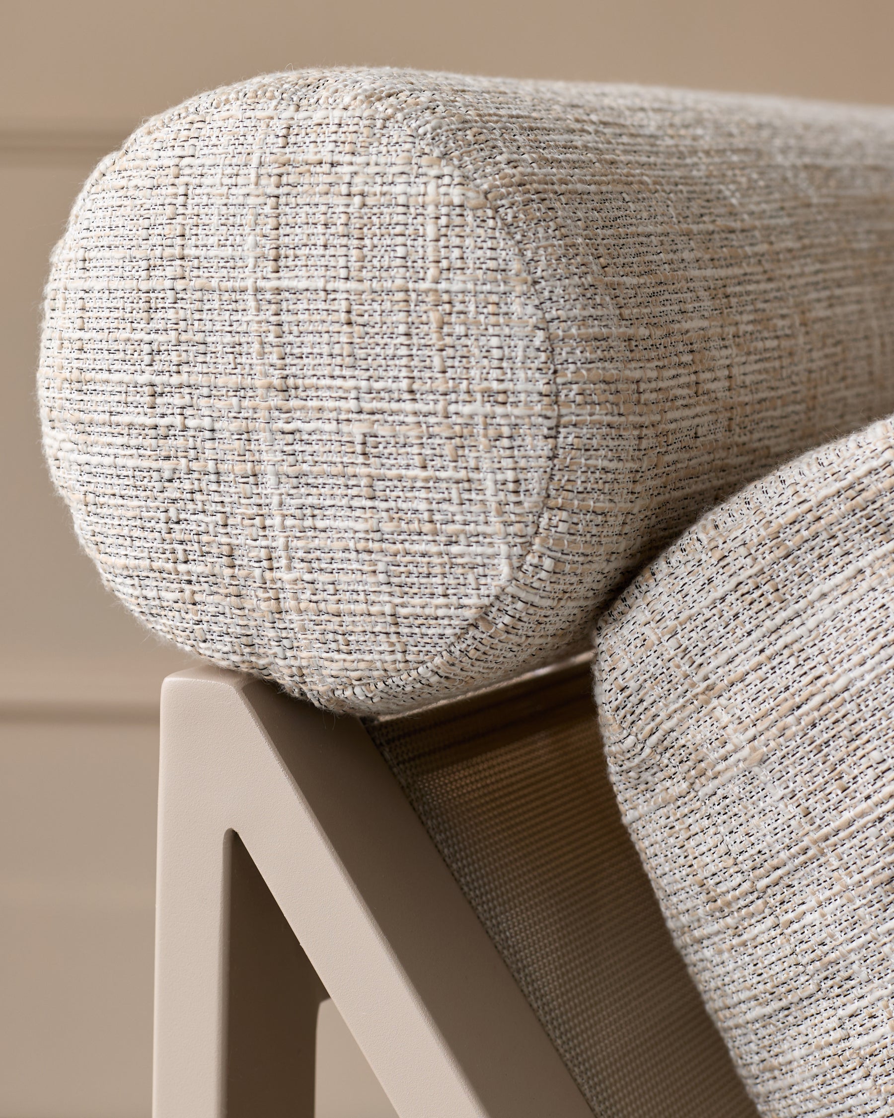 Close-up of natural woven textile on Verano lounge chair armrest and back, showing cream fabric weave detail.