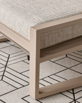 Verano lounge chair with natural wooden base and beige upholstery, close-up of armrest and leg detail on patterned rug.