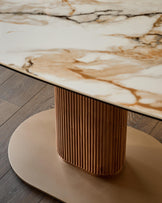 Vidal 6-seater dining table with natural ceramic top and ribbed wood pedestal base on round platform.