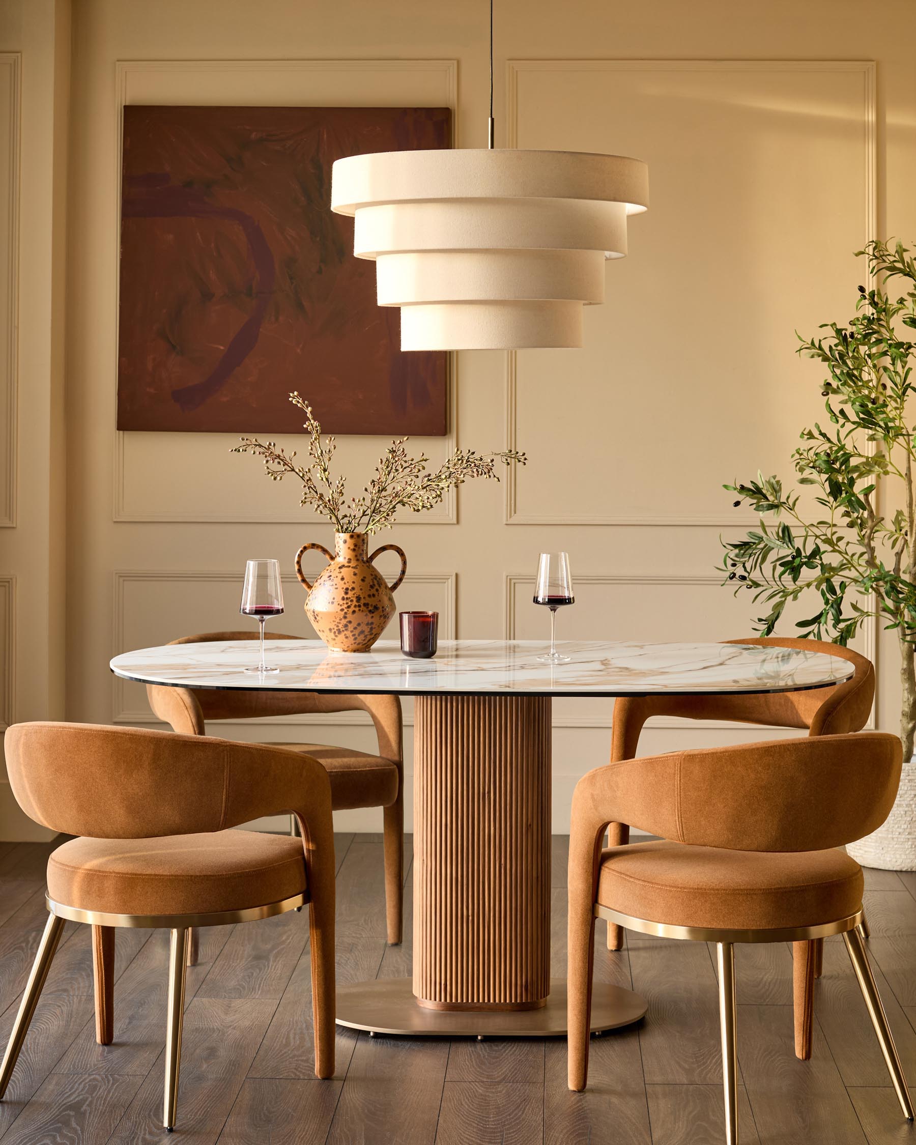 Vidal 6-seater dining table in natural ceramic with round marble top and fluted wood base, styled with chairs.