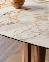 Vidal extending dining table with cream marble top featuring natural veining and fluted wood base detail.