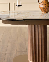 Vidal extending dining table with marble top, wooden fluted pedestal base, and metal frame detail.