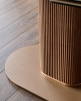Vidal extending dining table with natural ceramic top and fluted wood base on wooden floor.