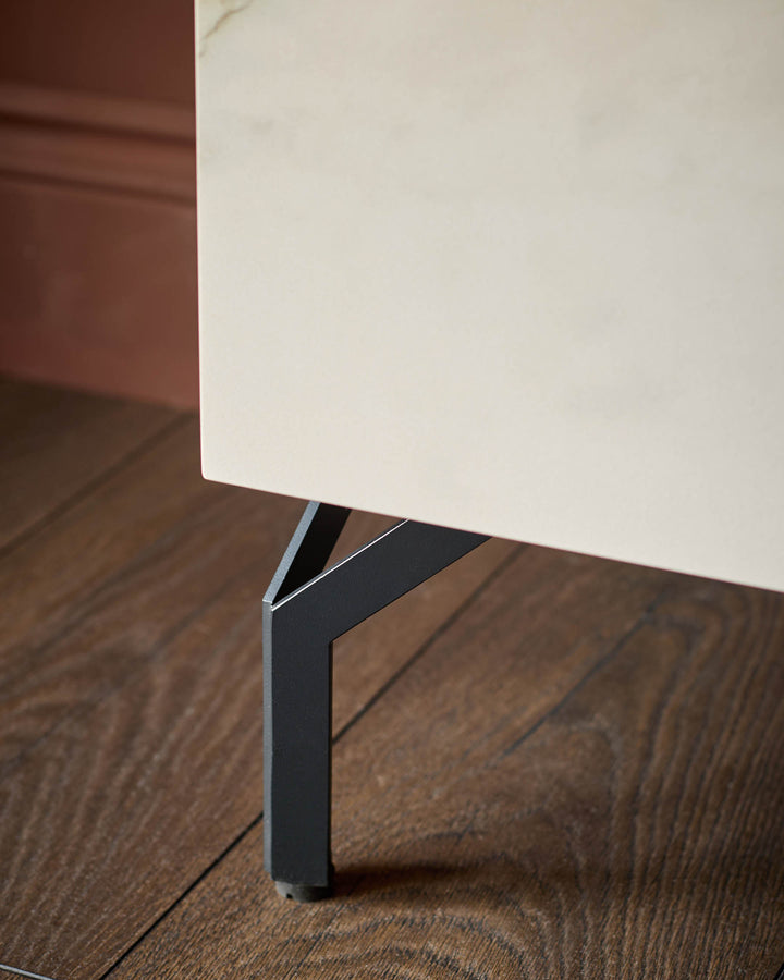 Winslow TV unit with ceramic natural finish, showing black metal leg detail on wood flooring.