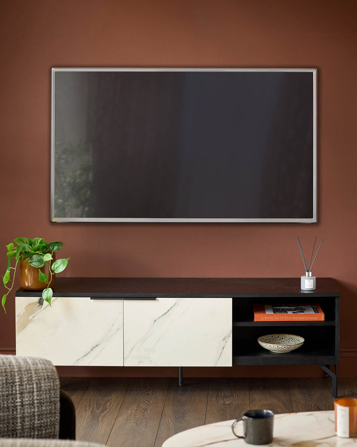 Winslow TV unit with marble-effect white doors, black shelving, and metal legs in a living room setting.