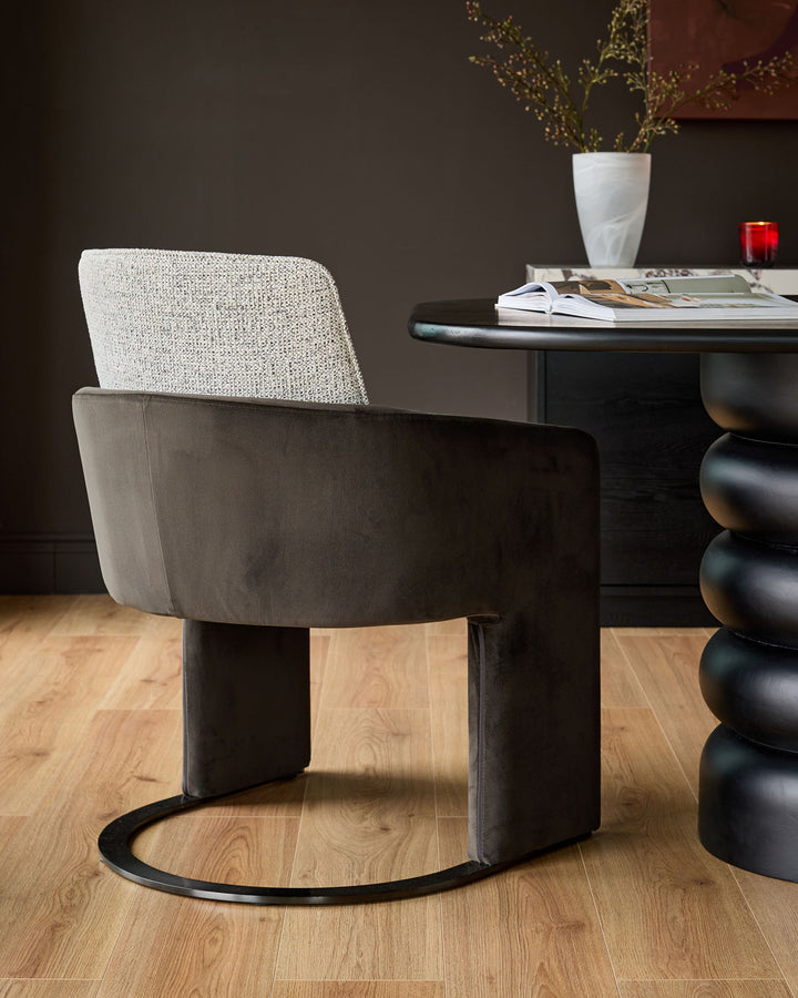 Wren cantilever dining chair in grey velvet and dark chocolate fabric, shown at an angle in a modern dining setting.