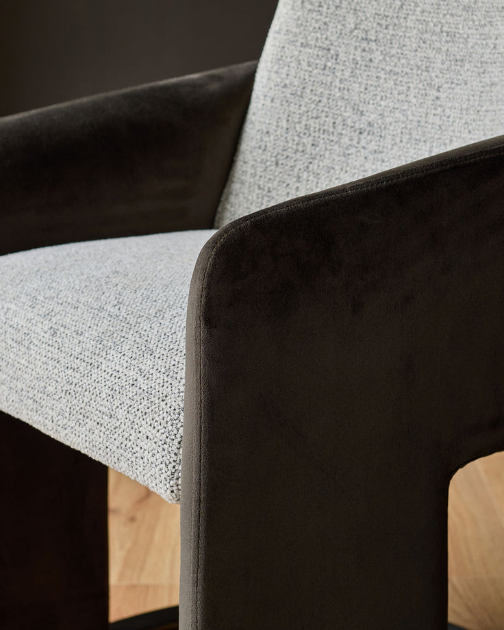 Grey fabric seat with dark chocolate velvet backrest and wooden legs, angled view.