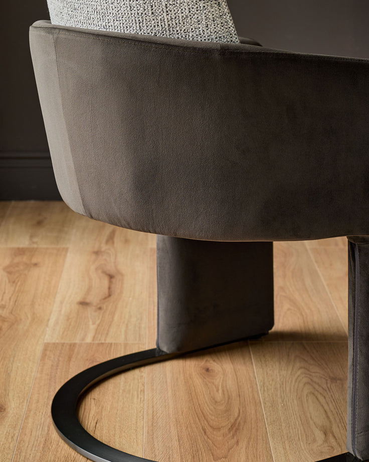 Wren cantilever dining chair in grey velvet and dark chocolate, shown at a side angle on wooden flooring.