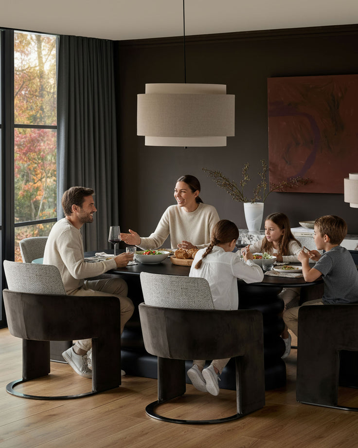 Wren cantilever dining chair in grey velvet and dark chocolate, shown at dining table with family.