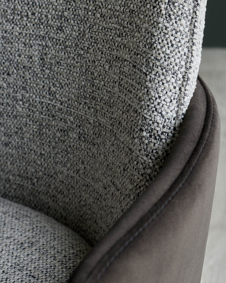 Close up of a stylish brown fabric chair, showing the textured material and sleek design detail.