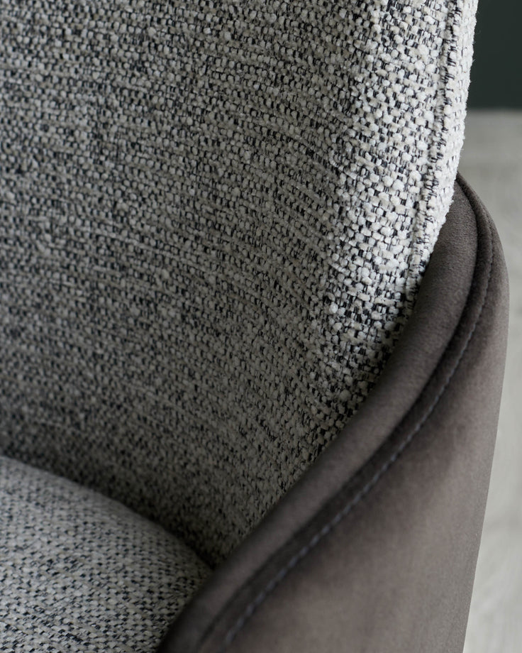Close up of a stylish brown fabric chair, showing the textured material and sleek design detail.