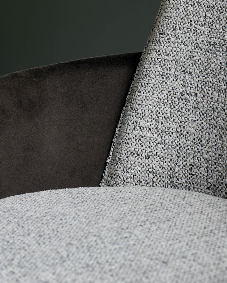 Close-up of a stylish armchair featuring a textured brown fabric and a sleek, dark brown velvet accent. Sophisticated comfort.