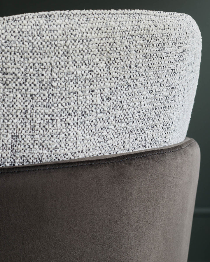 Close-up of a two-tone chair featuring a textured brown fabric and a brown suede effect material.