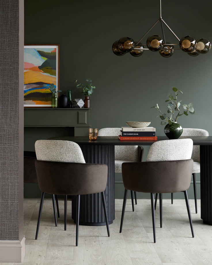 A dining room with a dark wood table and six upholstered chairs with dark metal legs, lit by a glass orb chandelier.