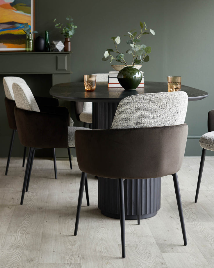 A stylish dining set with a dark wood table, complemented by upholstered chairs with sleek, black legs.