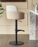 Wren gas lift bar stool in natural fabric and faux leather with black metal base, shown in kitchen setting.