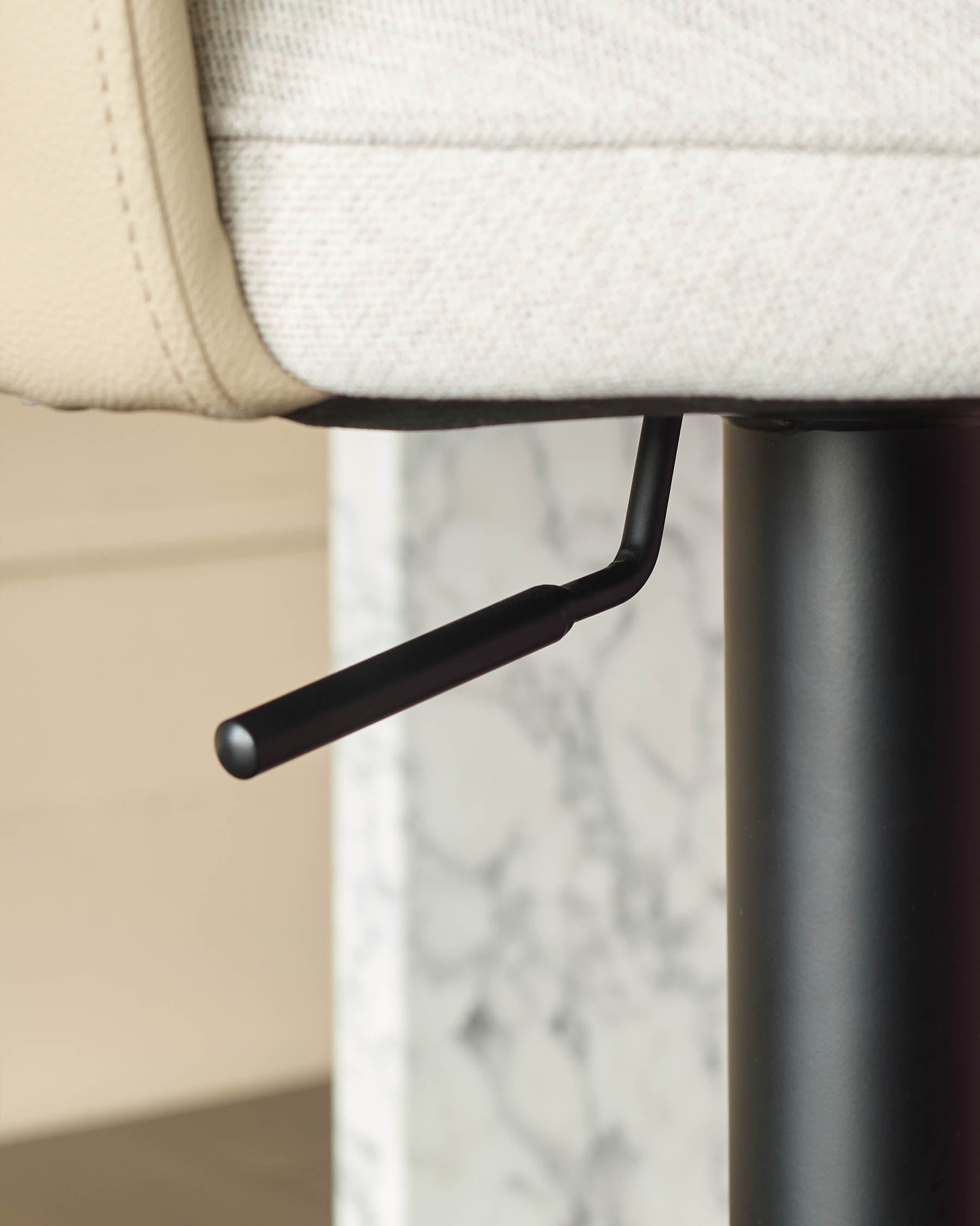 Wren gas lift bar stool with cream fabric seat, black curved footrest, and marble-effect base detail.
