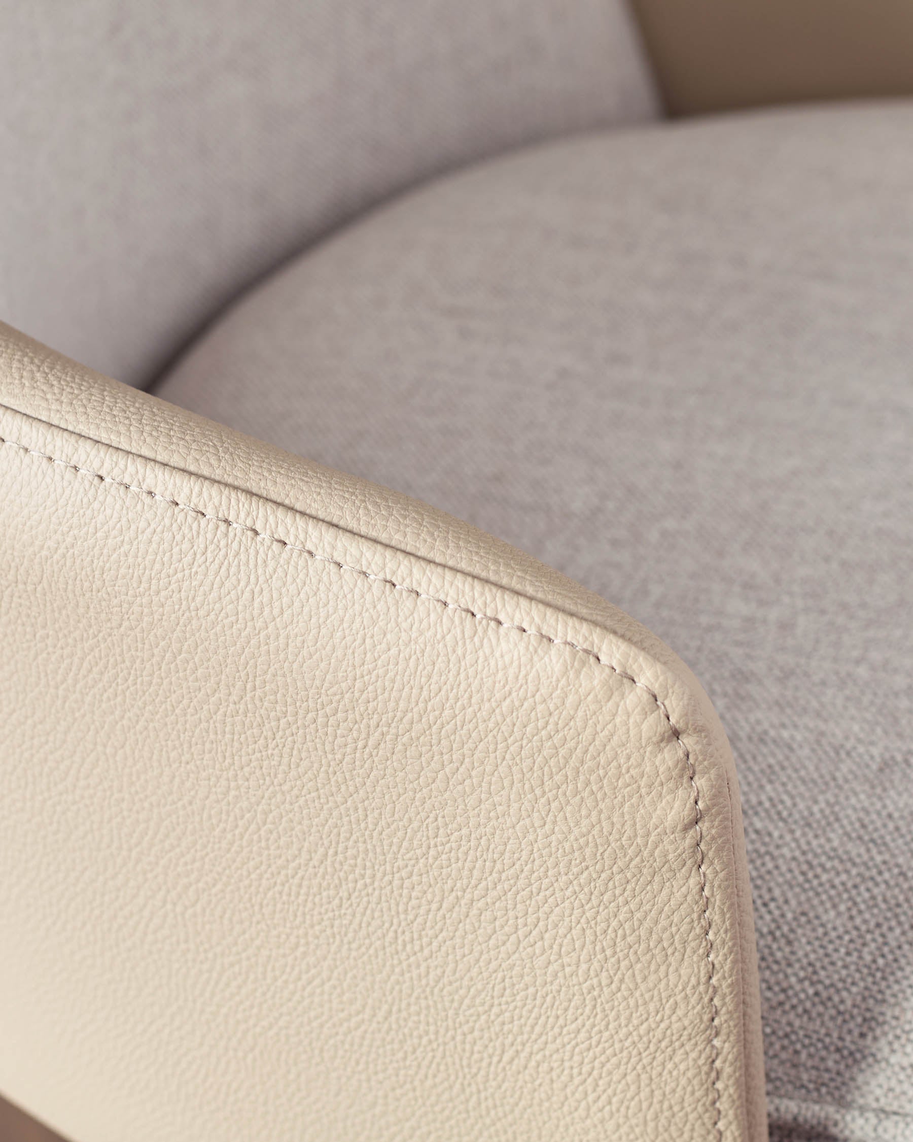 Close-up of cream faux leather seat with visible stitching detail on Wren gas lift bar stool.