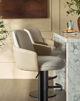 Wren gas lift bar stool in natural fabric and faux leather with black metal base, shown in kitchen setting.