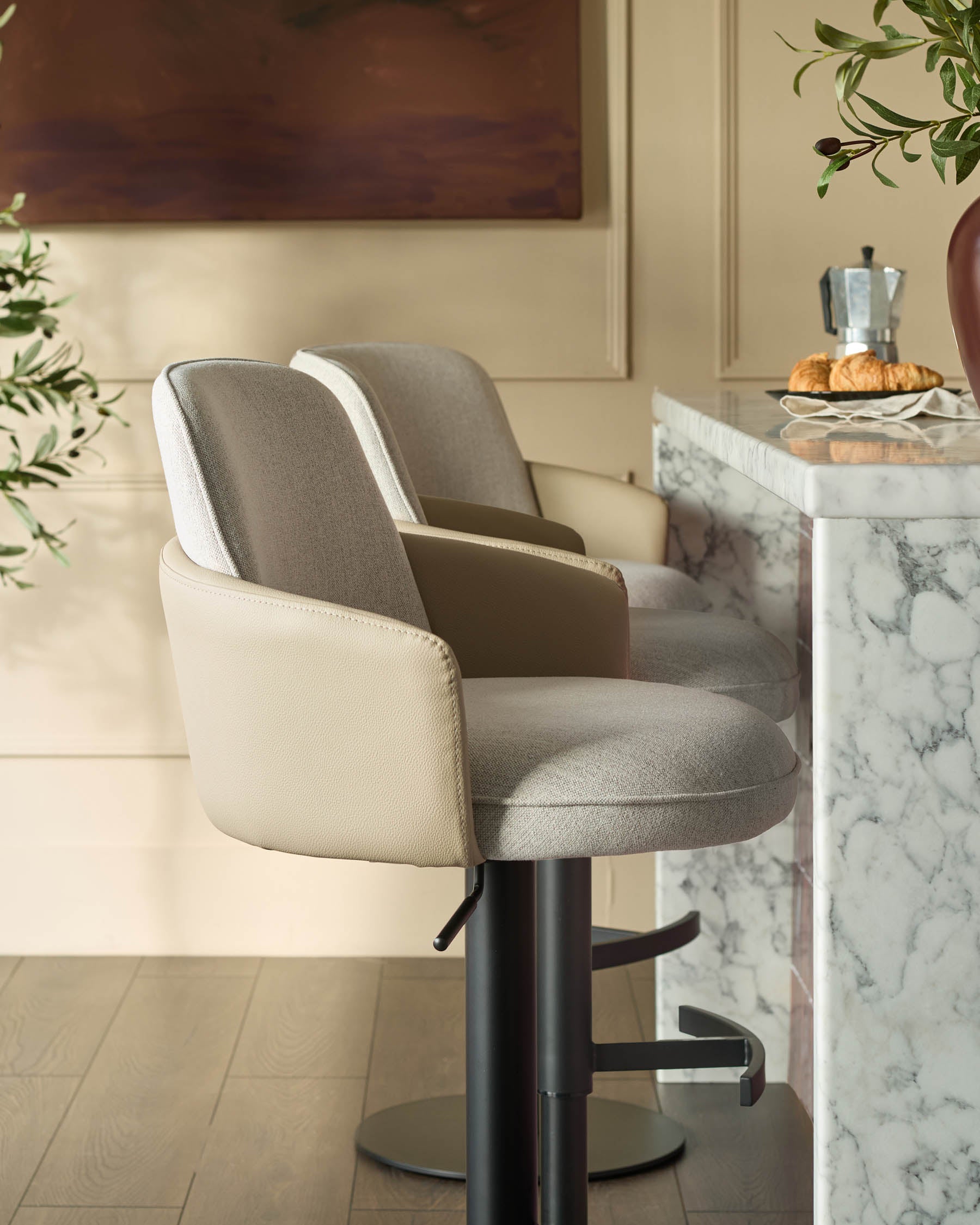 Wren gas lift bar stool in natural fabric and faux leather with black metal base, shown in kitchen setting.
