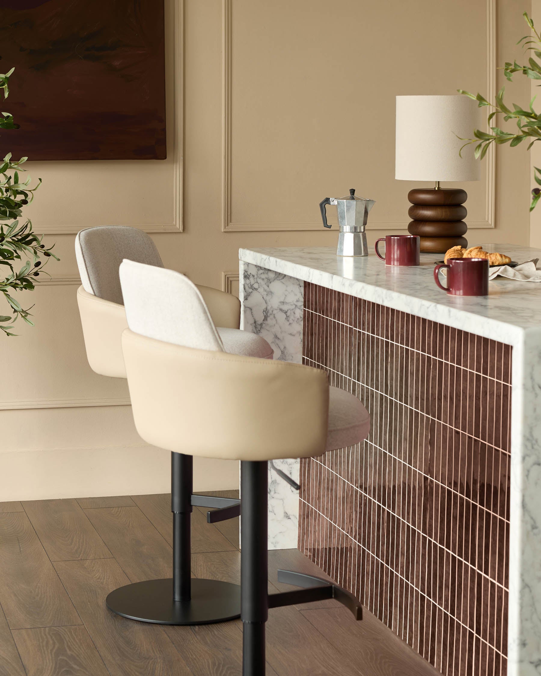 Wren gas lift bar stool in natural faux leather with black metal base, shown at kitchen counter.