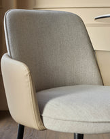Wren dining chair in natural fabric and faux leather, shown at an angle highlighting the curved backrest and seat cushion.
