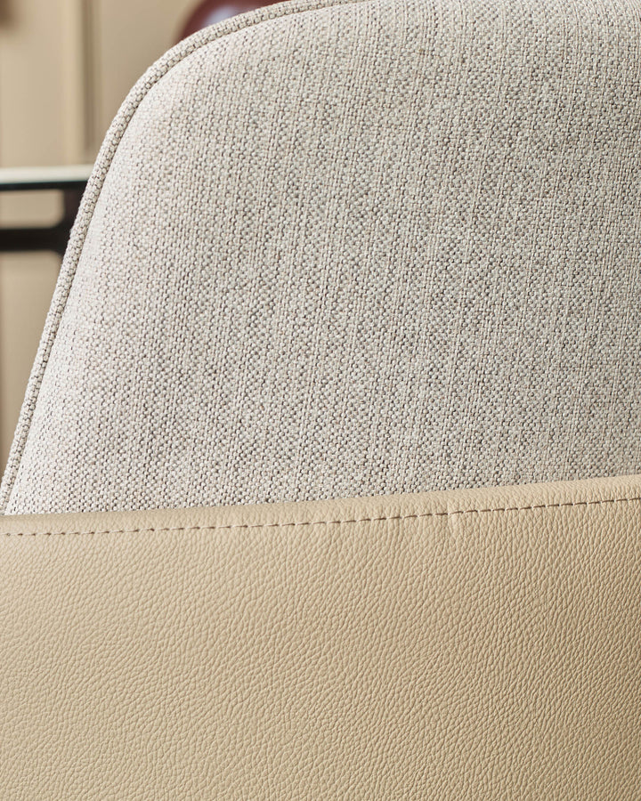 Wren dining chair showing close-up of natural fabric and faux leather seat detail with stitched seam.