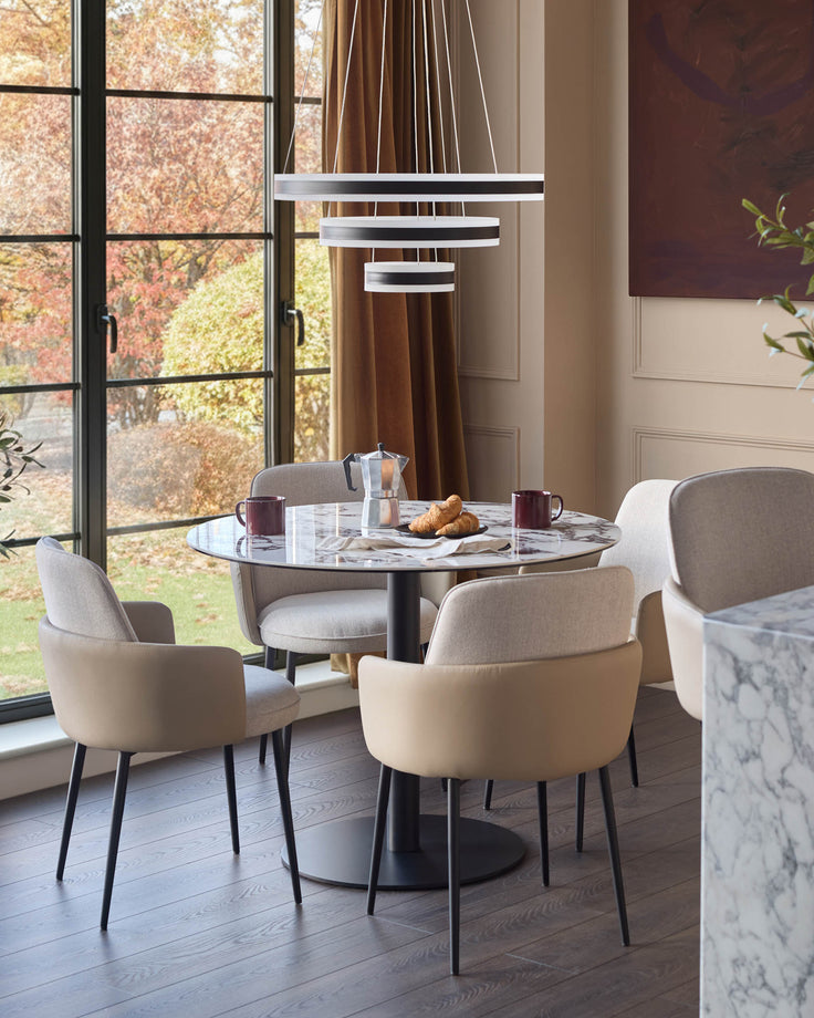 Wren dining chair in natural fabric, shown in a modern dining room setting around a marble table.