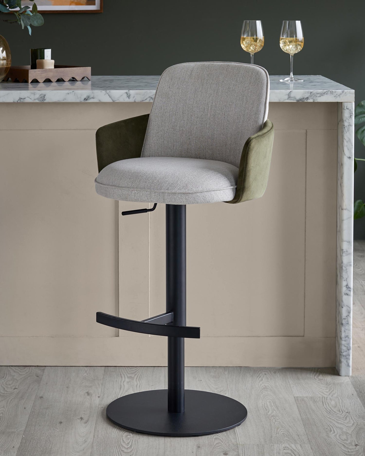 A stylish grey and green bar stool with a black metal base, perfect for modern kitchen counters.