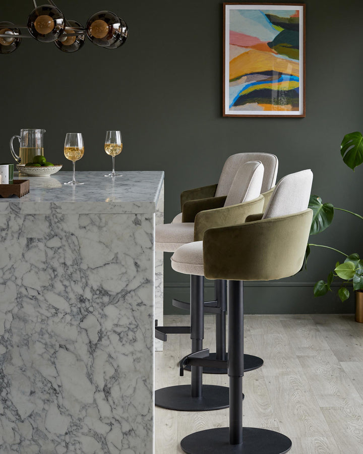 Two bar stools with marble counter, olive and neutral fabric. Modern design.