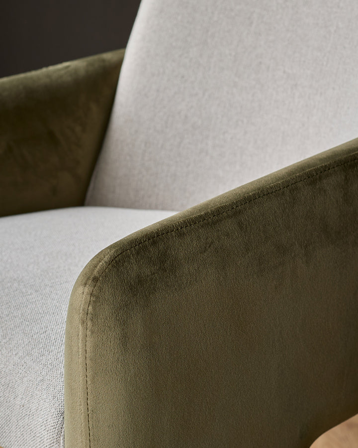 Wren dining chair detail showing olive-green velvet armrest against natural fabric seat and backrest.