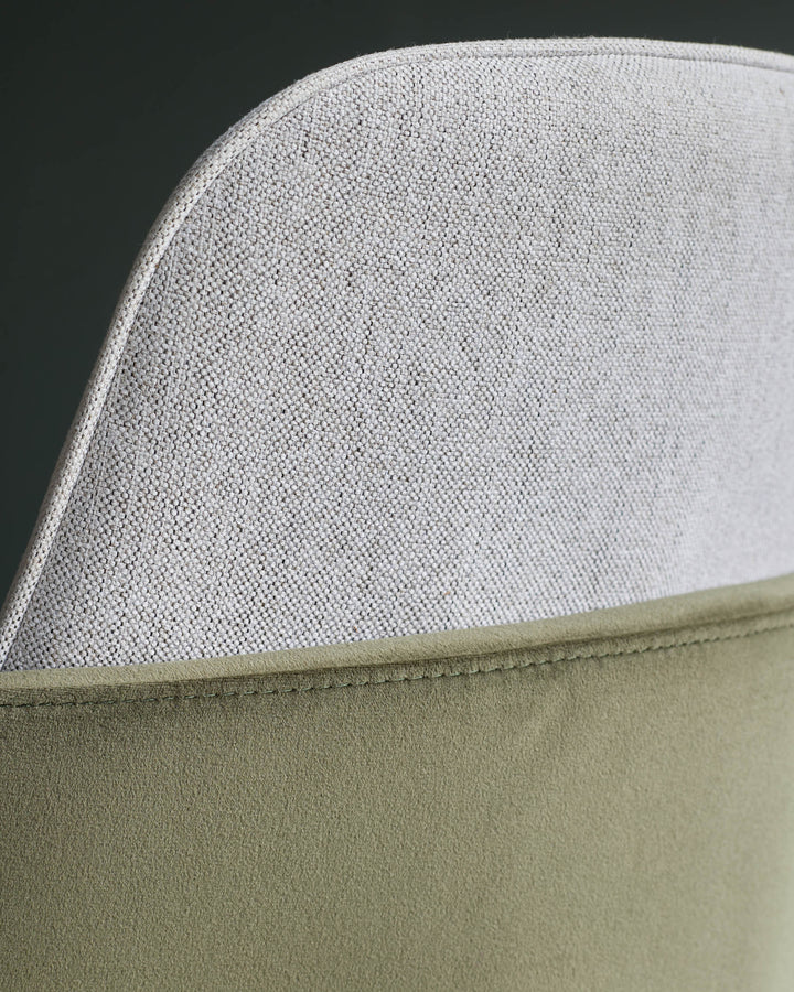 Close-up of a modern chair featuring a textured light grey back and a soft olive green seat.